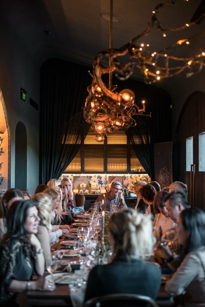 A large group of people eat dinner at a fancy restaurant